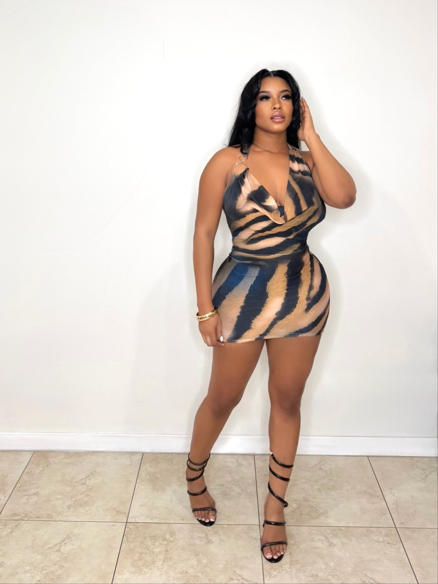 Woman wearing a zebra print dress against a white wall