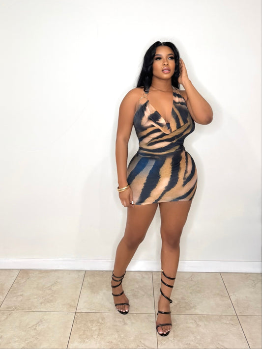 Woman wearing a zebra print dress against a white wall